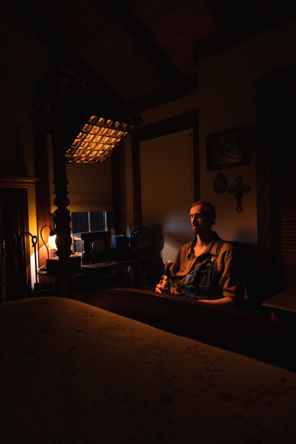 A dark, warm interior lit by a single lamp