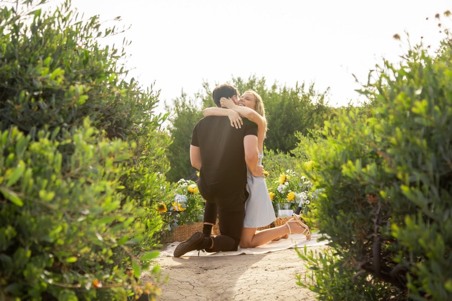 A couple embrace on a garden path in the late afternoon
