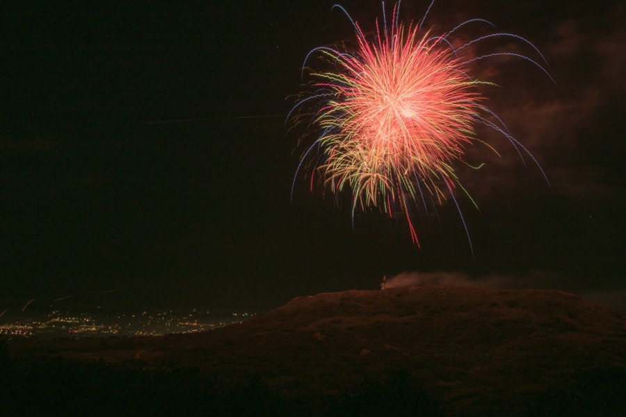 A single firework opening over a dark valley