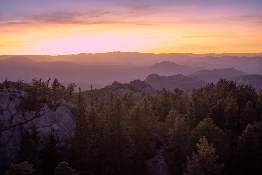 Layered mountain ridges under a pink and violet sunset