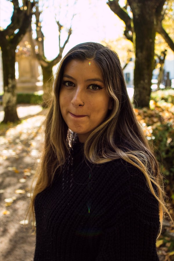 A woman backlit in a grove of dappled light