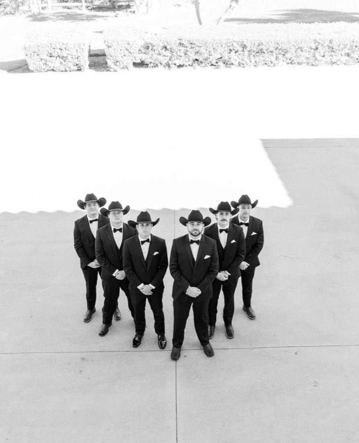 Overhead black and white frame of the groomsmen lined up on pavement
