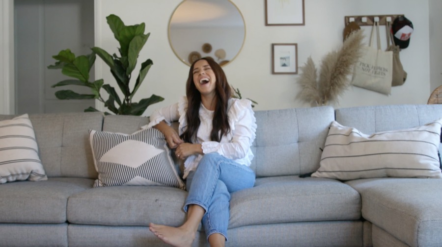 A woman laughing on a sofa during a commercial shoot